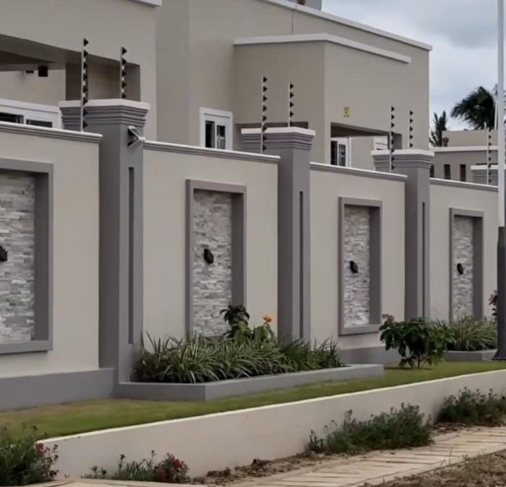 Cream fence wall with grey pillars, stone-cladding panels and planters
