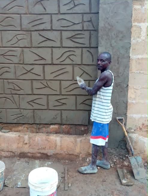 Craftsman carving a brick pattern into a freshly plastered wall
