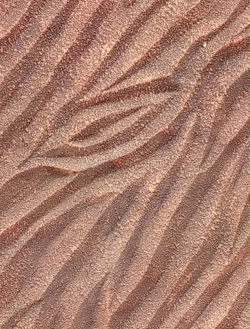 Close-up of a flowing ridged wall texture in terracotta