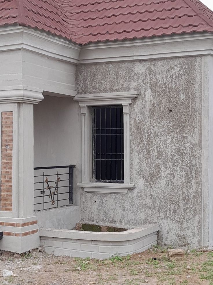 Window hood and frame on a textured house wall beside a porch column