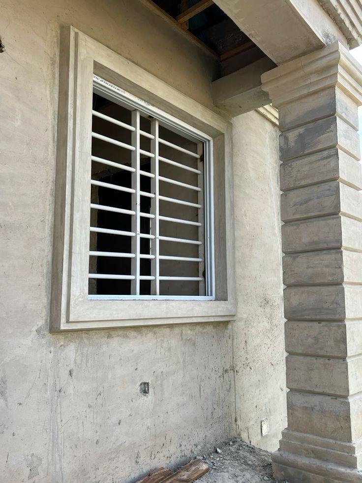 Window frame moulding beside a banded porch pillar