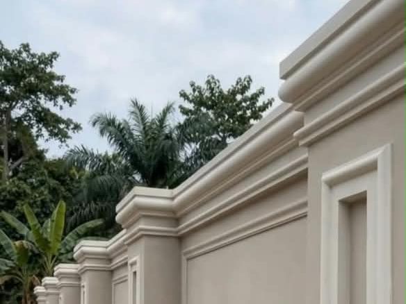 Fence pillars topped with moulded flower caps and cornice